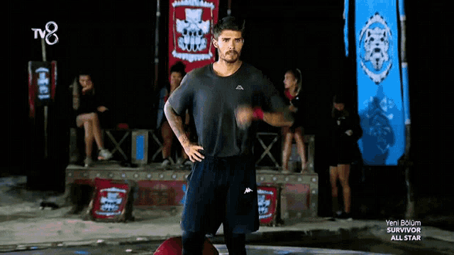 a man stands in front of a banner that says survivor all star on it