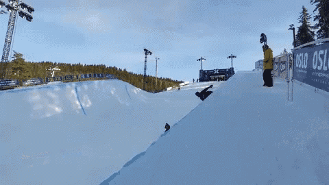 a snowboarder is doing a trick on a snowy slope