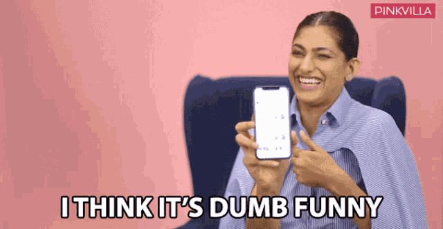 a woman holding a cell phone with the words i think it 's dumb funny on the bottom