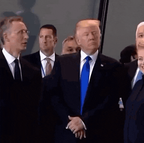 a group of men in suits and ties are standing around donald trump .