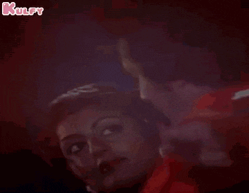 a man and a woman are dancing together on a stage in a dark room .