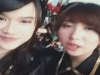 two women are posing for a picture together while wearing headphones .