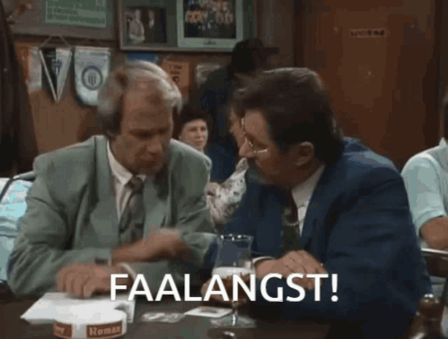 two men are sitting at a table with the words faalangst written on the screen