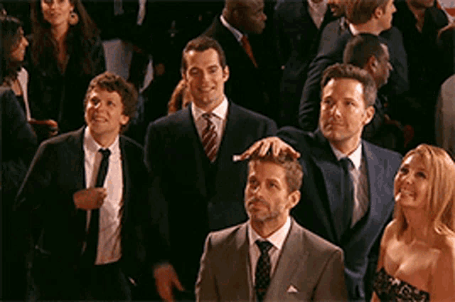 a group of people in suits and ties are standing together