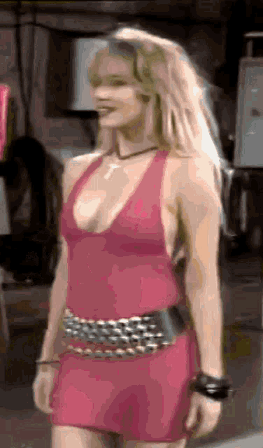 a woman in a pink dress with a black belt