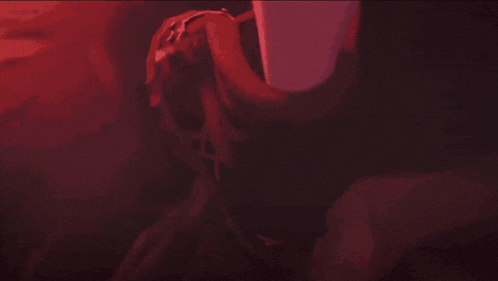 a white light is shining through a red umbrella