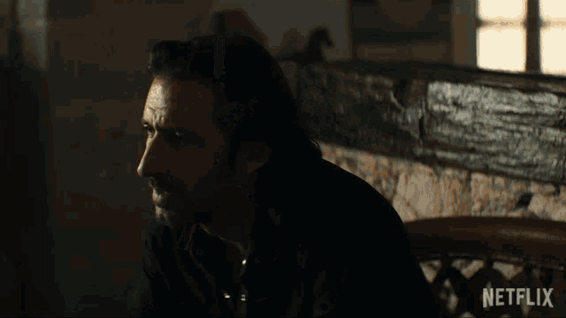 a man in a dark room with a netflix logo on the bottom right