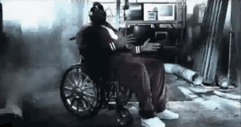 a man in a wheelchair is hugging another man in a gym .