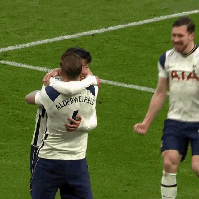 a soccer player with the name alderweireld on his back is hugging another player