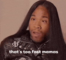 a man with long hair is wearing a leather jacket .