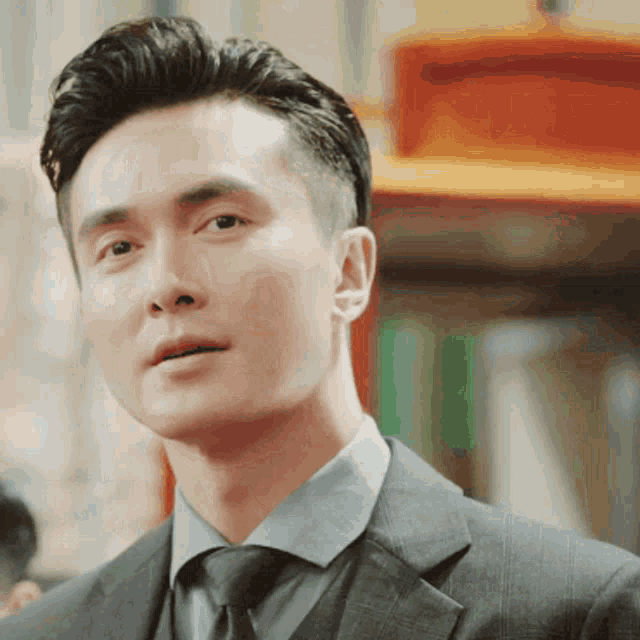 a man in a suit and tie is looking at something