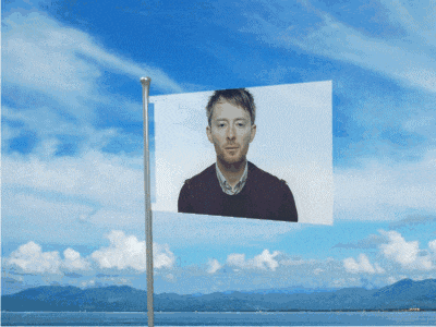 a flag with a picture of a man on it in front of a blue sky