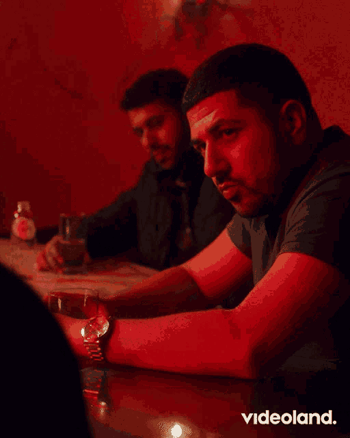 a man sitting at a table with videoland written on the bottom right