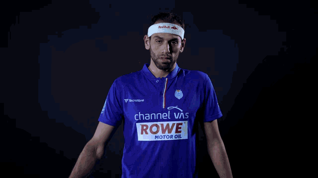 a man wearing a blue shirt that says channel vns rowe motor oil on it