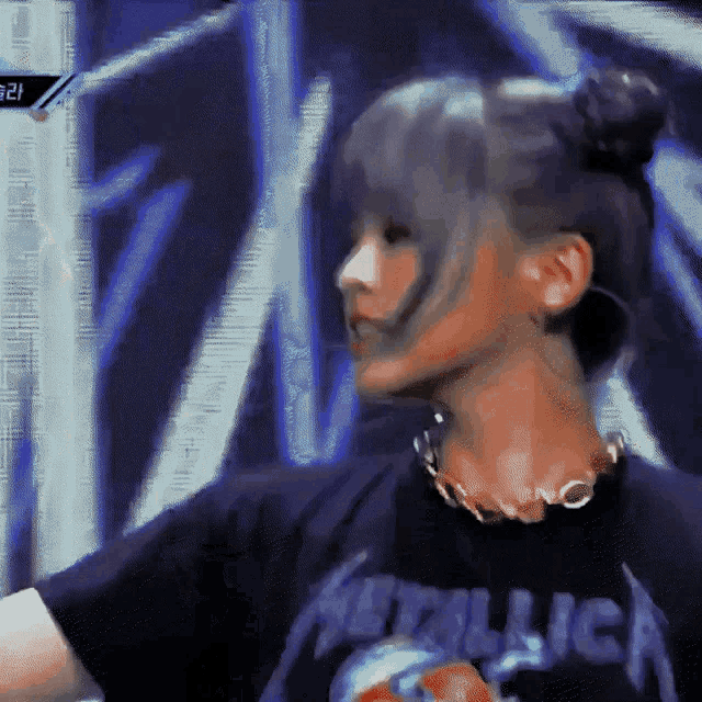 a woman wearing a metallica t-shirt and a necklace