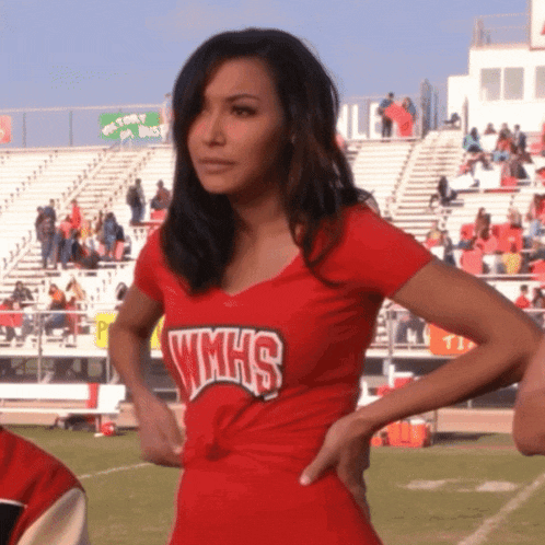 a woman in a wmhs shirt stands on a field