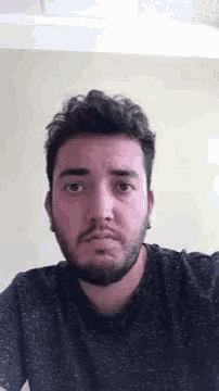 a man with a beard and earrings is making a funny face .