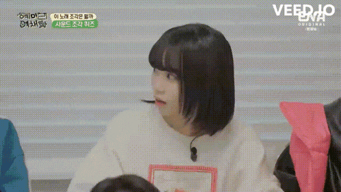 a girl with korean writing on her face is sitting down