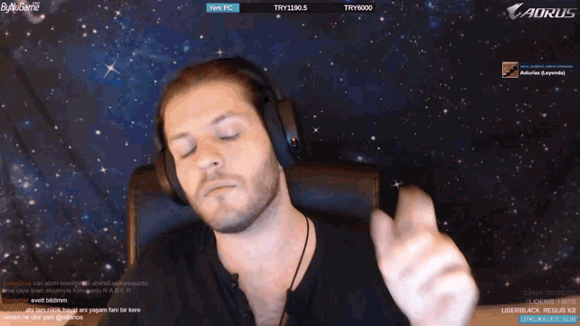 a man wearing headphones is playing a game on a aorus computer