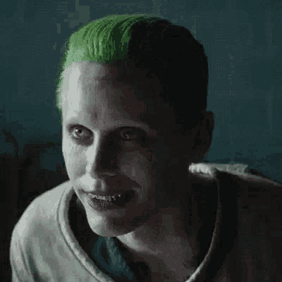 the joker from the movie suicide squad has green hair and a scar on his face .