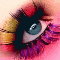 a close up of a woman 's eye with colorful eye shadow