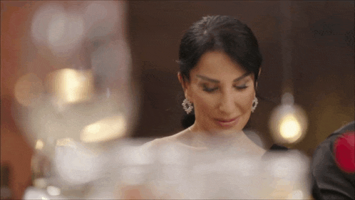 a woman in a white dress and earrings is looking down