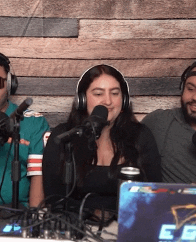 a woman wearing headphones is speaking into a microphone in front of a laptop that says ee