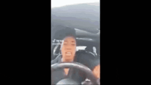 a man is driving a car and making a face .