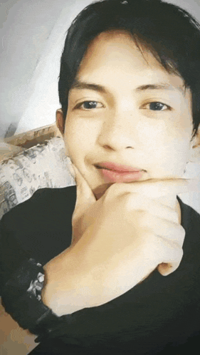 a young man with his hand on his chin