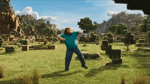 a man in a blue shirt is dancing in a field of trees