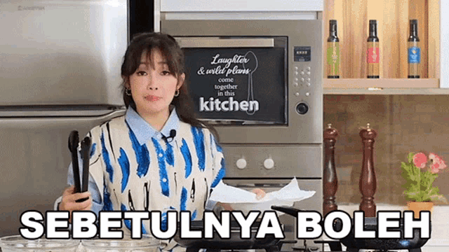 a woman cooking in a kitchen with a sign that says laughter and wild plums come together in the kitchen