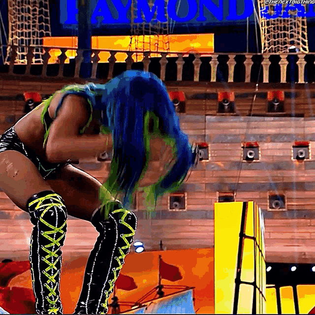a woman with blue and green hair is kneeling down in front of a sign that says ' aaron '