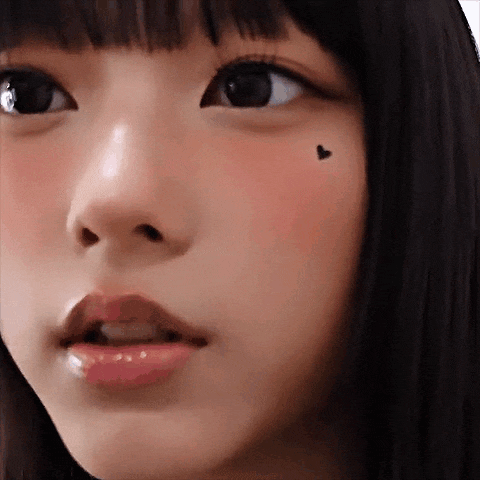 a close up of a young girl 's face with a heart on her cheek .