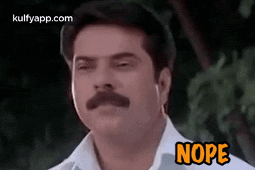 a man with a mustache and a white shirt is making a funny face and says nope .