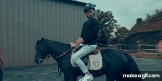 a man wearing a helmet is riding a horse
