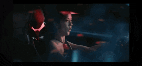 a woman is driving a car in the dark and smiling .