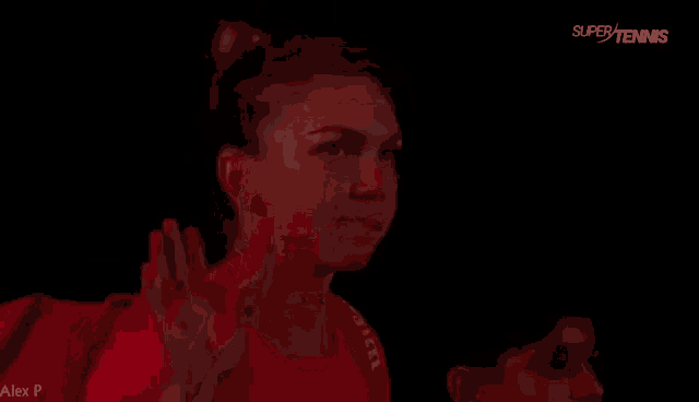 a woman in a red shirt waves her hand in the dark