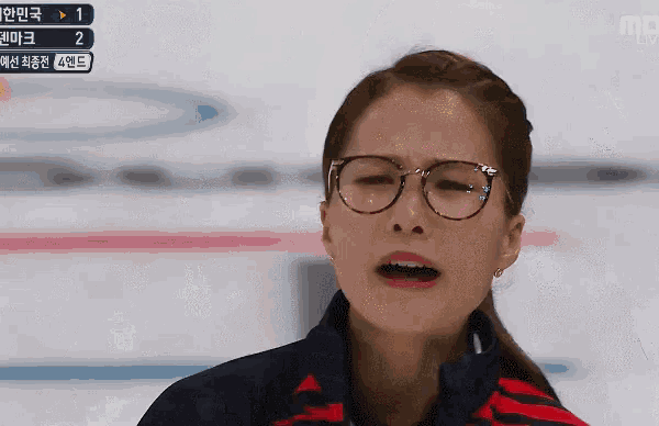 a woman wearing glasses is making a funny face while watching a game on mbc