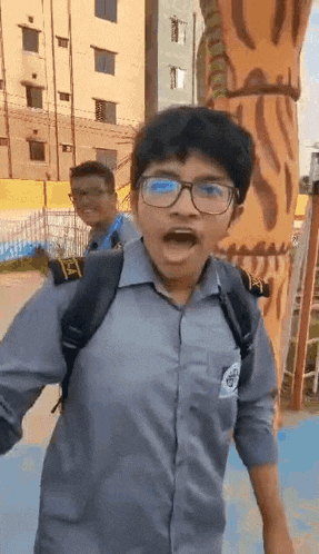 a boy wearing glasses and a backpack is standing in front of a tiger statue and making a funny face .