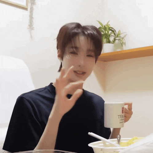 a young man is holding a white mug that says temp on it