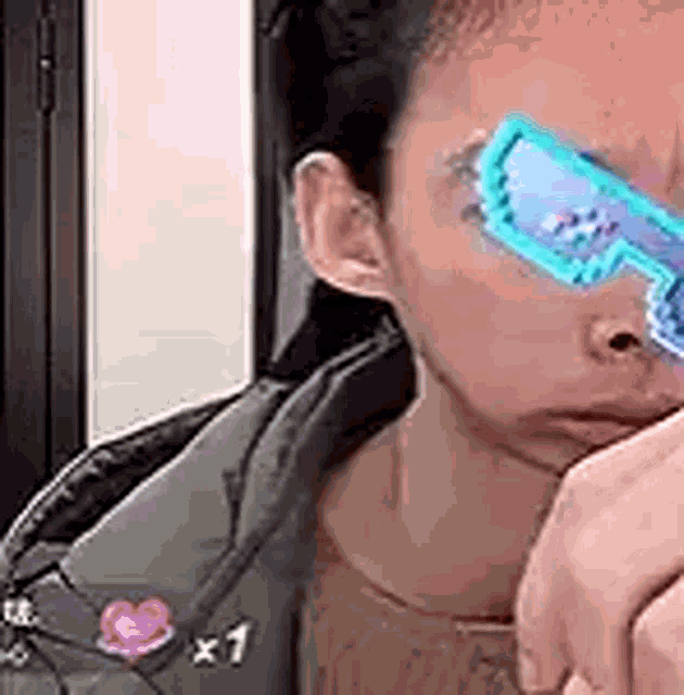a close up of a person wearing blue sunglasses covering their eyes .