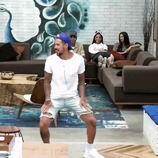 a man in a white shirt is dancing in front of a group of people