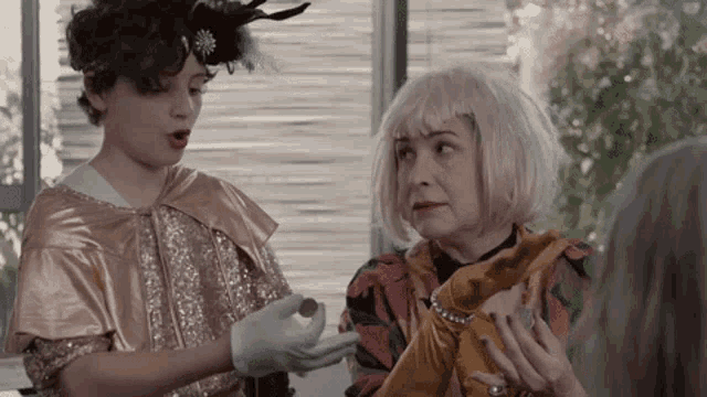 a woman with blonde hair is talking to a young girl