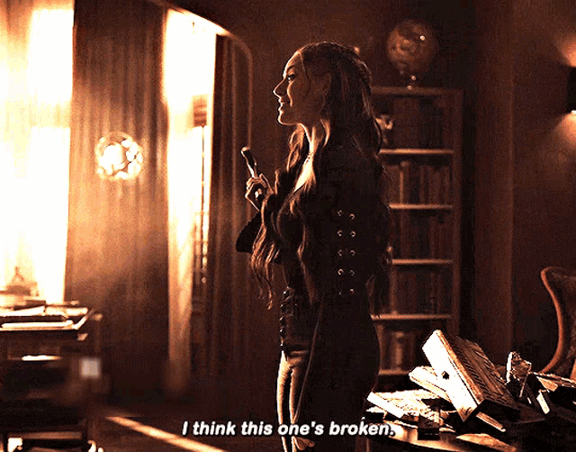 a woman stands in a dark room holding a microphone and says i think this one 's broken