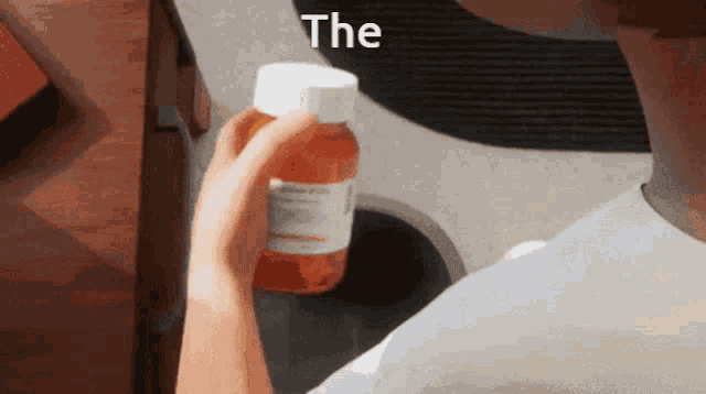 a person holding a bottle of pills that says the on the top