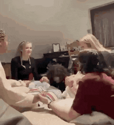 a group of people are sitting around a table with a dog .