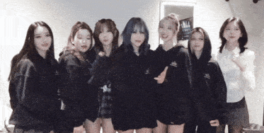 a group of women are posing for a picture and one of them has a hoodie that says ' nct ' on it