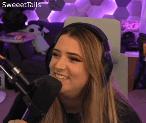a woman wearing headphones is talking into a microphone .