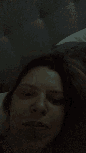 a close up of a woman 's face in a dark room