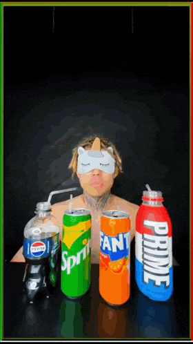 a man wearing a cat mask is surrounded by sprite fanta and pepsi cans